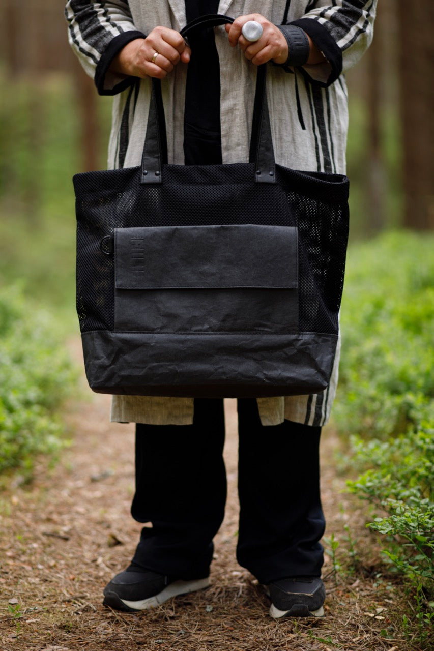 Person holding black Fiilii kraftex bag. 