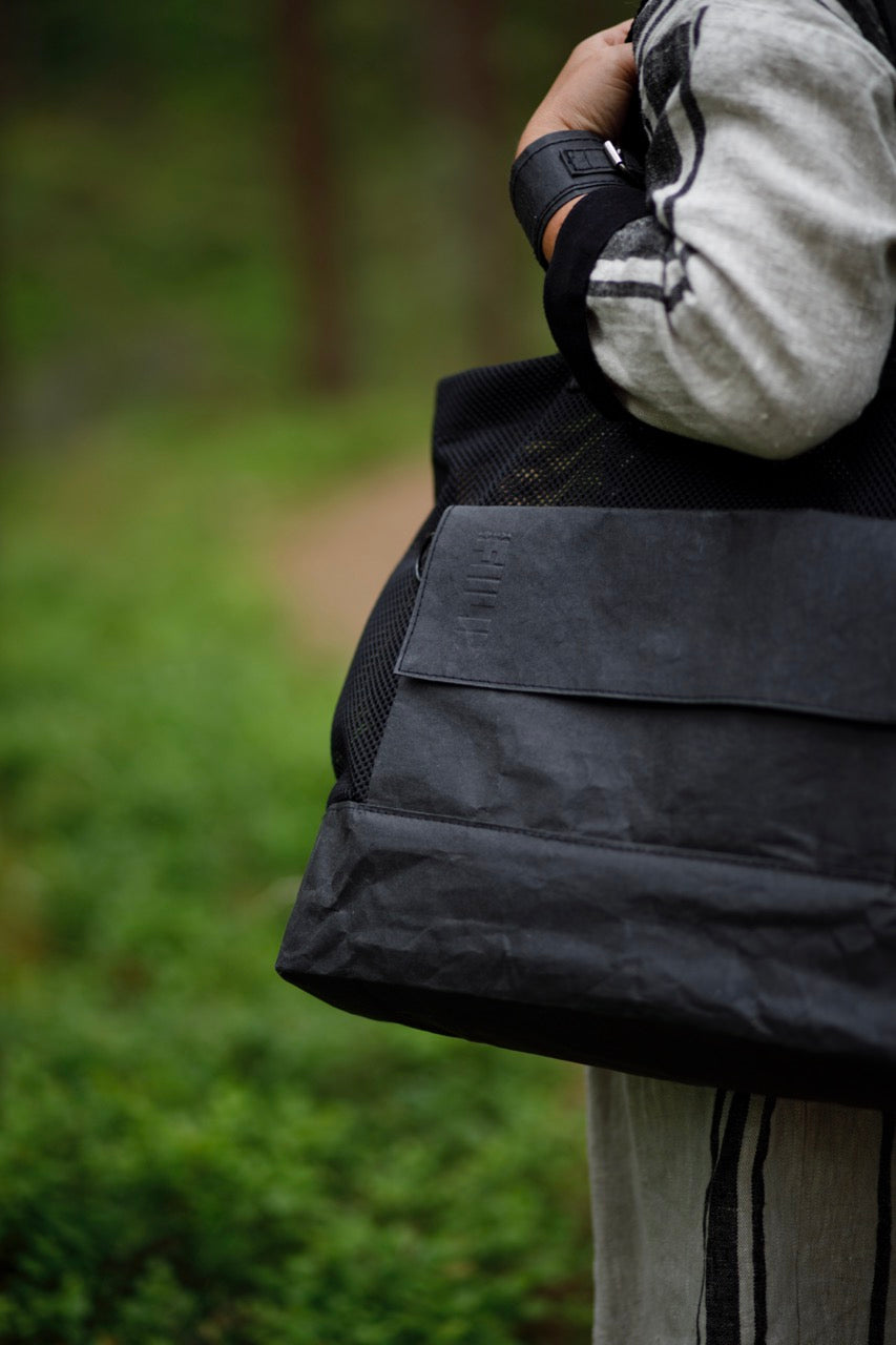 Side of black Fiilii design kraftex bag on persons shoulder.